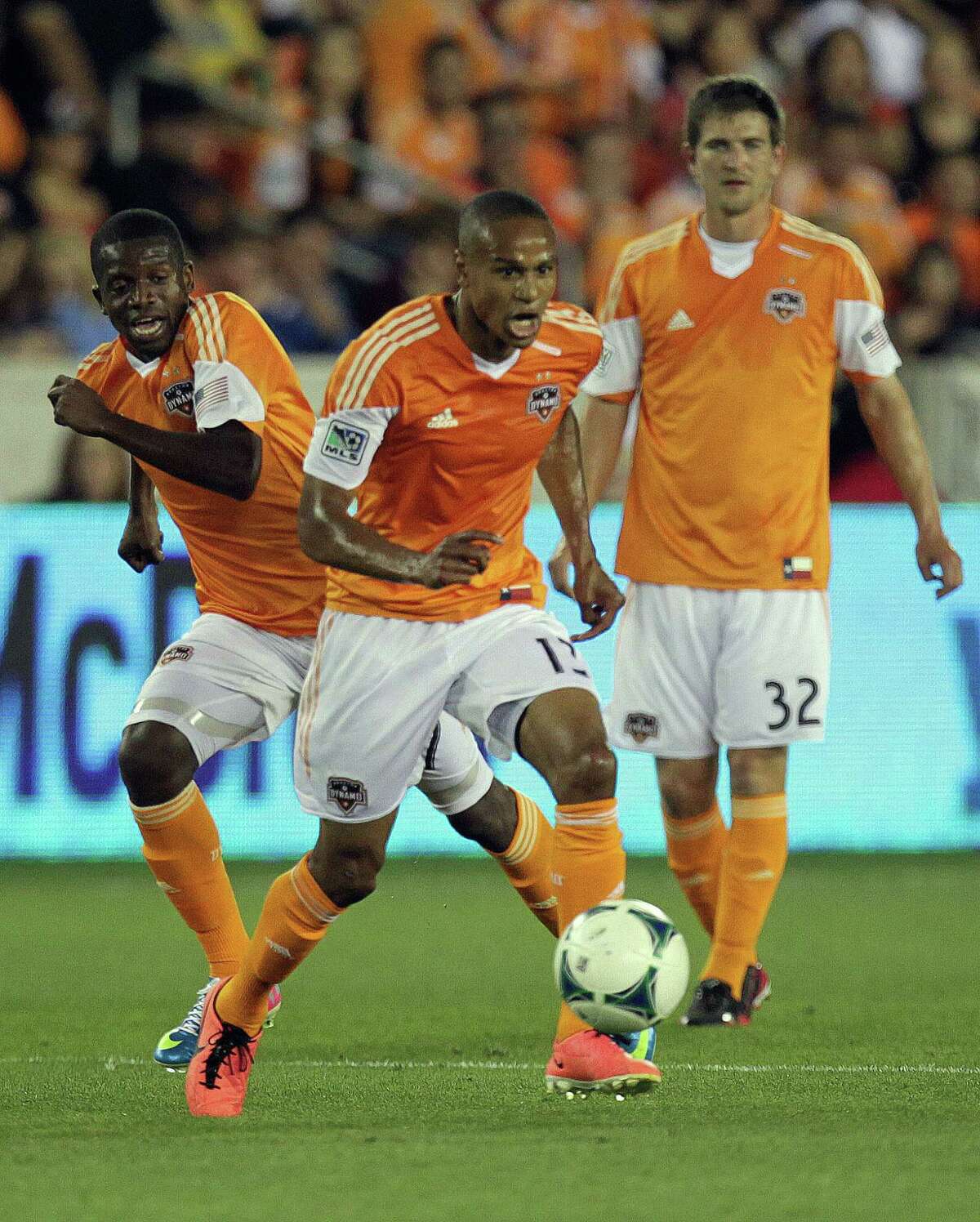 The Houston Dynamo midfielder Ricardo Clark center, moves the ball against the San Jose Earthquakes as his teammates Boniek Garcia left, and Bobby Boswell right, look on during the first half of MLS soccer game action against the San Jose Earthquakes at BBVA Compass Stadium Saturday, March 30, 2013, in Houston .