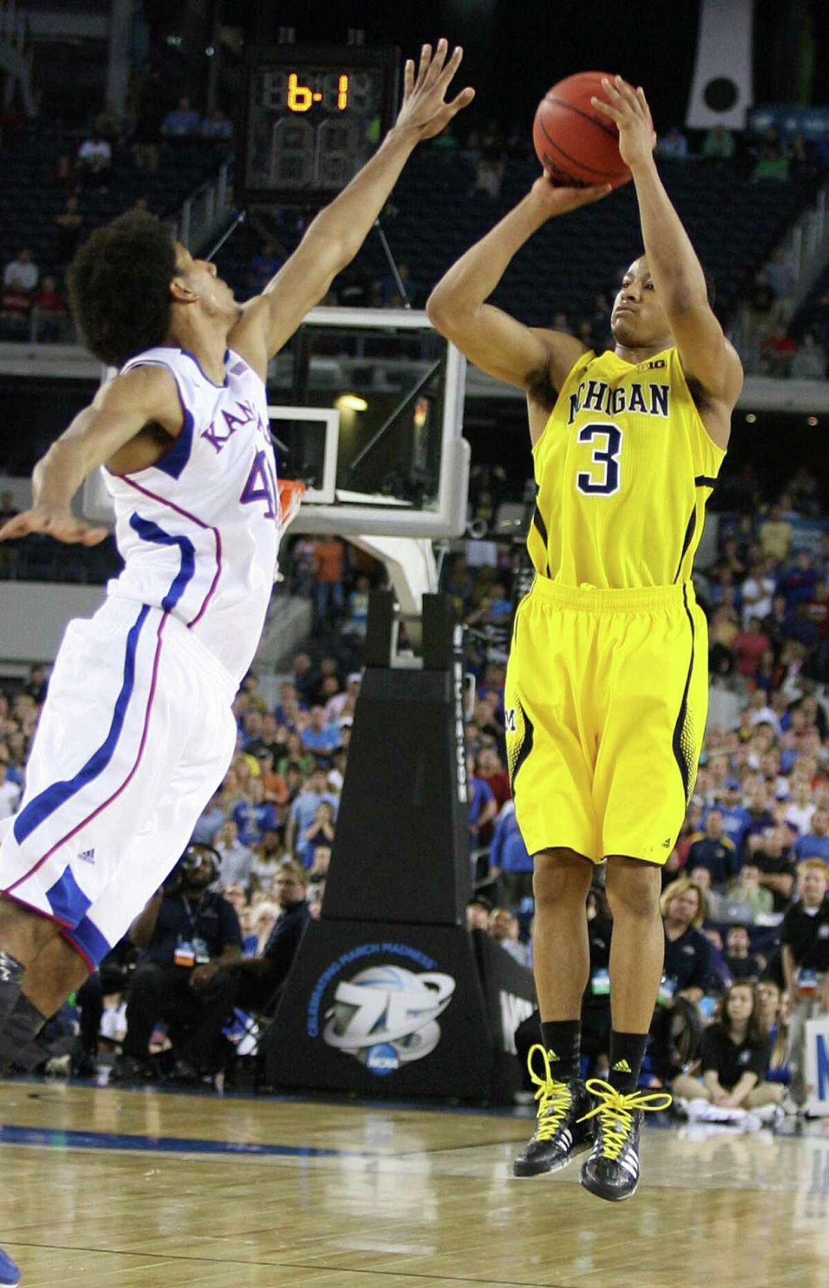 Michigan's Trey Burke scored 23 points, including this 3-pointer against Kansas' Kevin Young in the final seconds that sent Friday's game to overtime.