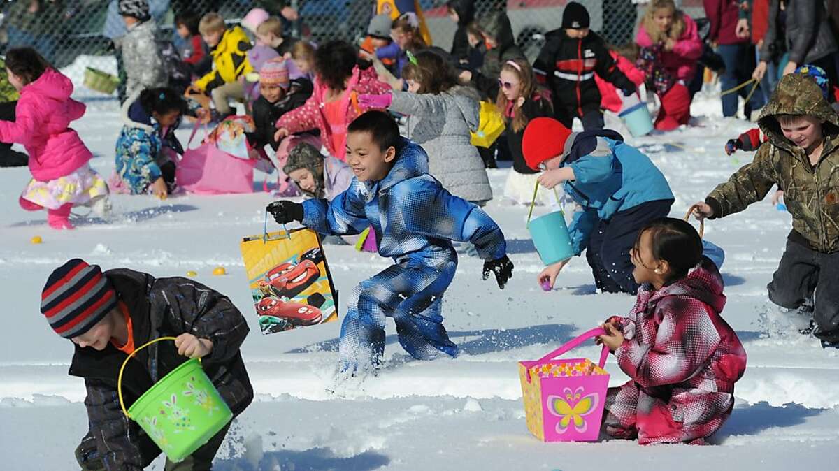 Children dashed through the snow while picking up about 10,000 plastic eggs that contained candy and prizes, including bicycles, during the annual Easter Egg Hunt at the Eagle River Lions Club Community Park in Anchorage, Alaska, on Sunday, March 31, 2013. (AP Photo/Anchorage Daily News, Bill Roth)