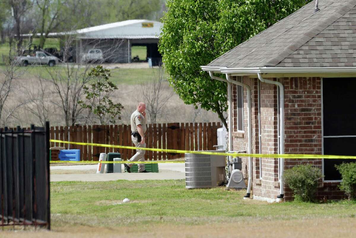 A Kaufman County Sheriff's deputy walks near the taped-off property of Kaufman County District Attorney Mike McLelland, near Forney, Texas, on Sunday, March 31, 2013. On Saturday, McLelland and his wife, Cynthia, were murdered in their home.