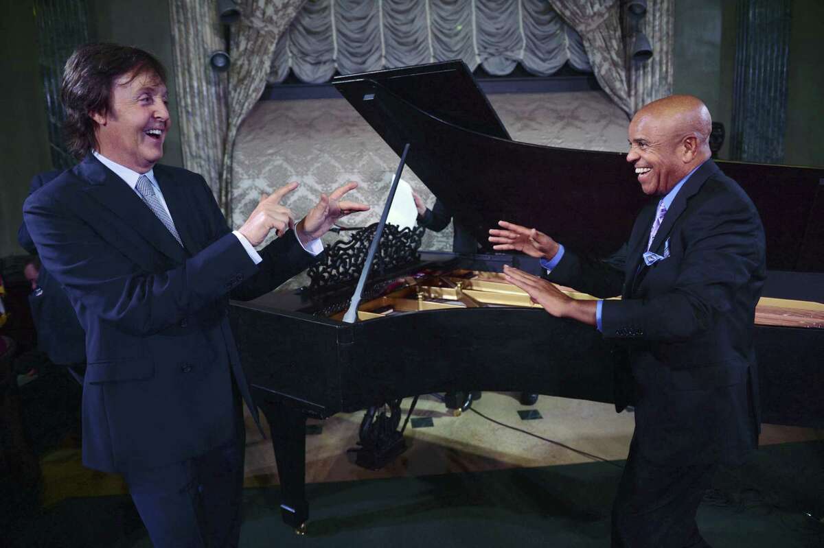 Paul McCartney (left) and Berry Gordy stand in front of Motown's newly restored 1877 Steinway grand piano.