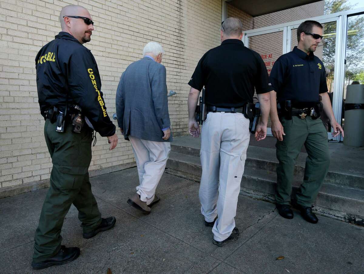 Kaufman County lawmen escort an employee inside the courthouse Monday as police throughout Texas were on high alert.