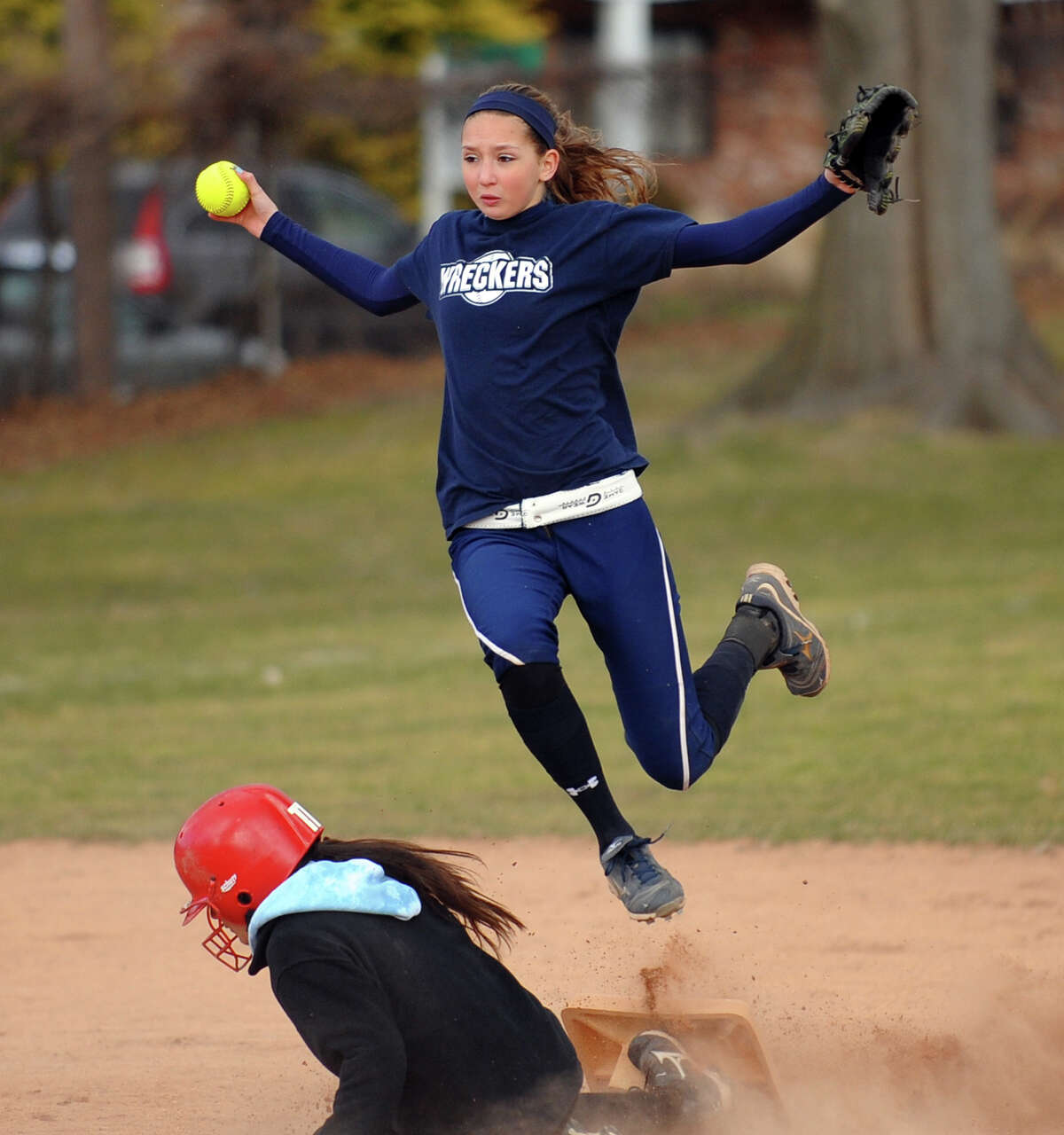 Staples' Nikki Bukovsky leaps over Westhill's Kate Brainard, during girls softball action in Westport, Conn. on Thursday March 28, 2013.