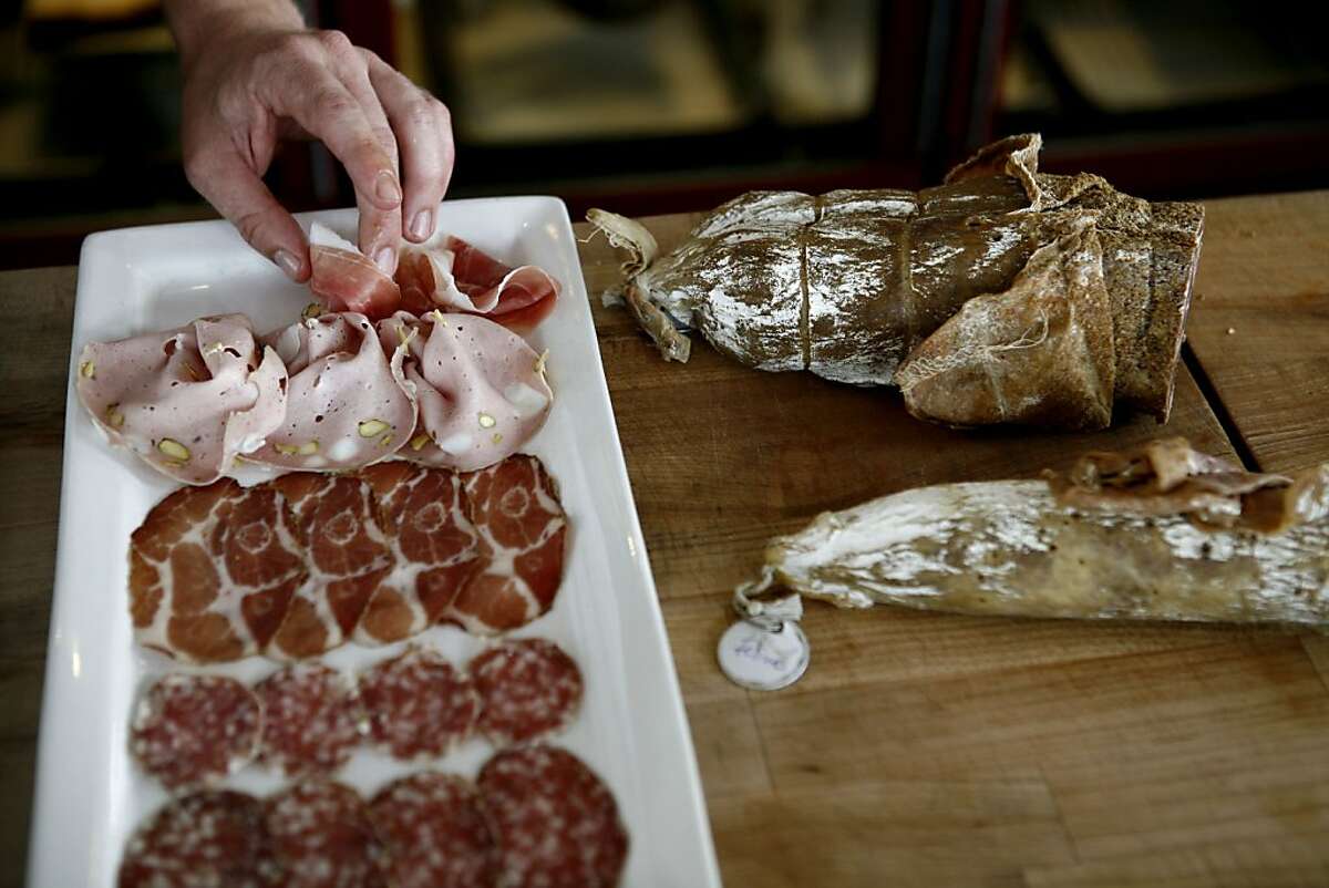 Greg Conger prepares the Emilia-Romagna salumi plate during happy hour at Adesso restaurant on Tuesday, July 6, 2010 in Oakland, Calif.