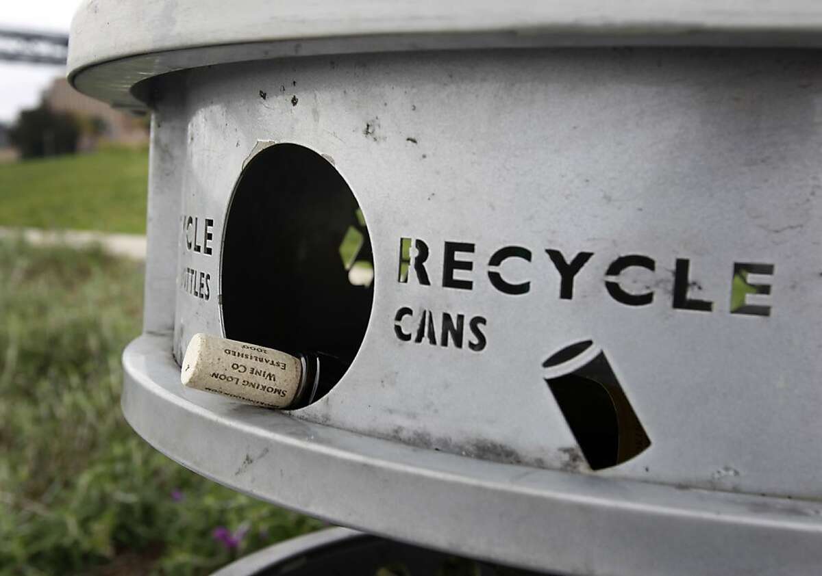 A wine bottle is left in a recycle and trash can on The Embarcadero in San Francisco, Calif. on Tuesday, April 2, 2013. City officials say it is too expensive to sort recyclables placed in the public waste canisters.