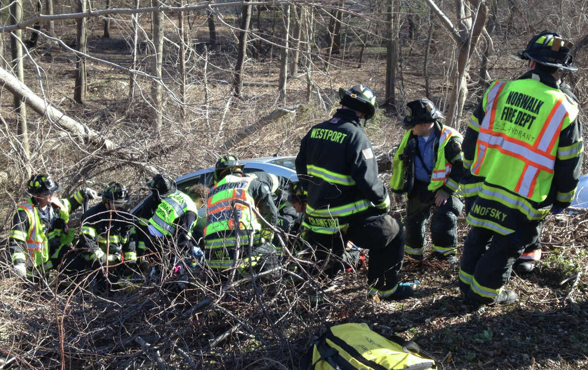 Firefighters from Westport and Norwalk at the scene of a crash Wednesday on the Merritt Parkway, between northbound Exits 40 and 41, where the driver was trapped in the car after it tumbled down an embankment and struck a tree. WESTPORT NEWS, CT 4/3/13