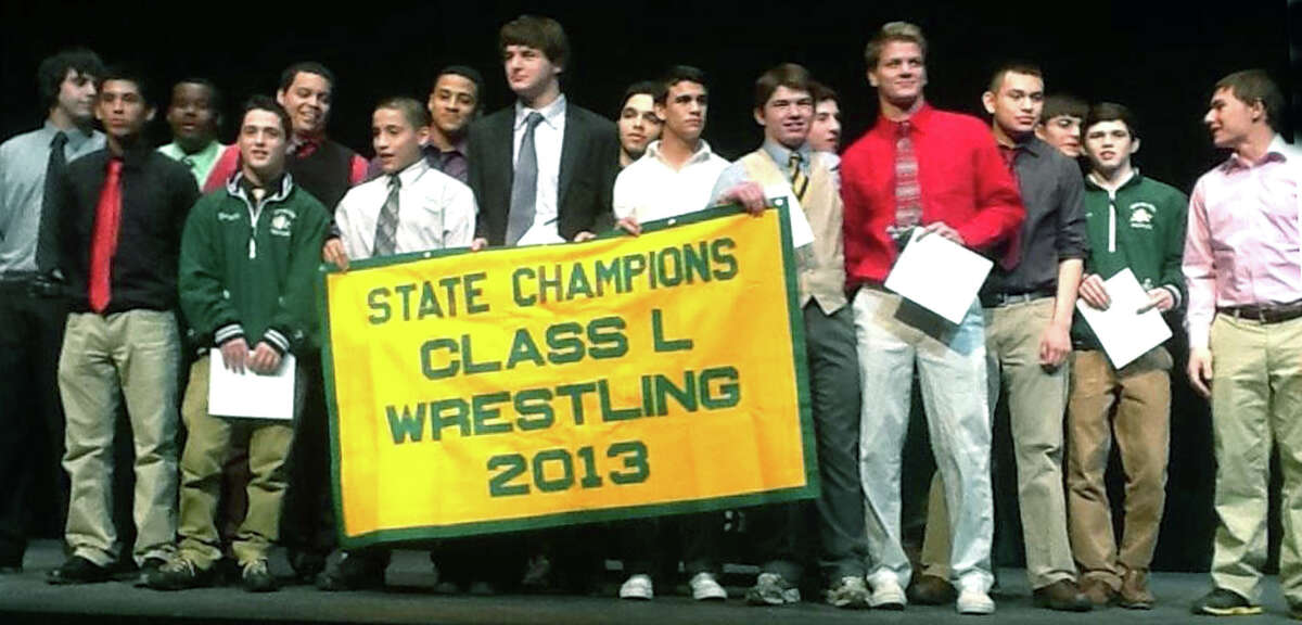 Athlets from the Green Wave wrestling team pose proudly with their state class 'L' championship banner during the March 27, 2013 winter sports awards ceremony at the school. Courtesy of Liz Curtis