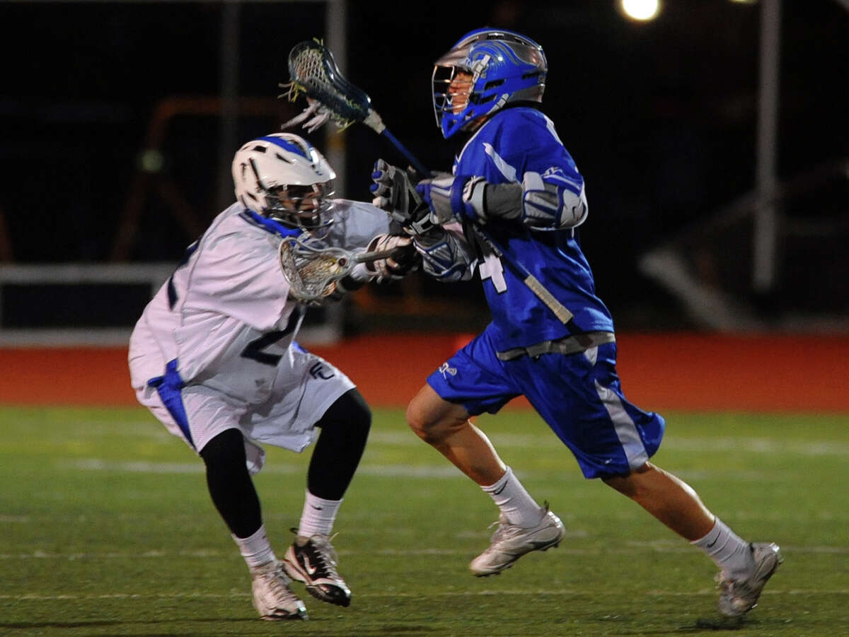 Fairfield Ludlowe's #22 Matthew Montanez, left, works to slow down Darien player #14 Kyle Cornell, during boys lacrosse action in Fairfield, Conn. on Wednesday April 3, 2013.