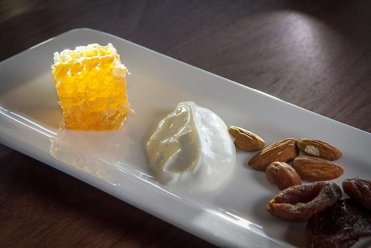 Local honey served in its comb, with Straus yogurt, Turkish apricots and almonds at the Exploratorium's SEAGLASS restaurant in San Francisco, Calif. are seen on Friday, March 29th, 2013.