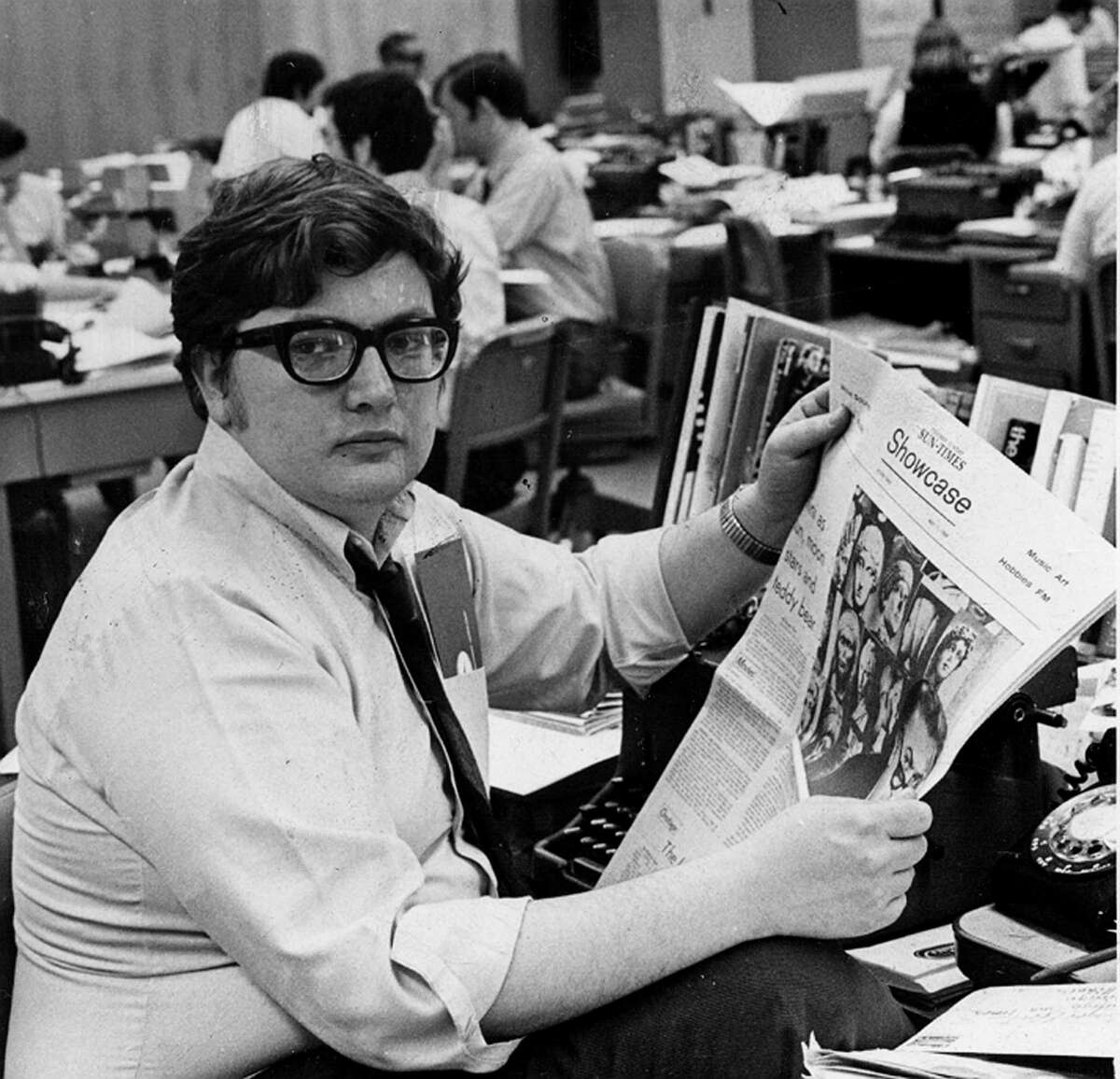 This 1969 photo shows Chicago Sun-Times movie critic Roger Ebert in the newsroom of the paper in Chicago. Ebert, the most famous and popular film reviewer of his time who became the first journalist to win a Pulitzer Prize for movie criticism and, on his long-running TV program, wielded the nation's most influential thumb, died Thursday, April 4, 2013. He was 70. (AP Photo/Chicago Sun-Times, Bob Kotalik)
