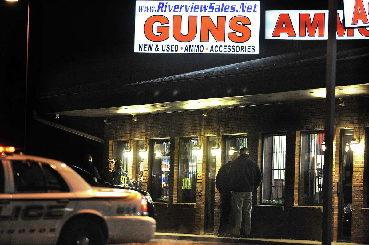 In this Dec. 20, 2012 photo, law enforcement officials stand outside Riverview Gun Sales, as authorities raid the store in East Windsor, Conn. The shop, which sold a gun to Nancy Lanza, mother of Newtown school shooter Adam Lanza, had its federal firearms license revoked by the Bureau of Alcohol, Tobacco, Firearms and Explosives, which confirmed the revocation Thursday, April 4, 2013. (AP Photo/Jessica Hill)