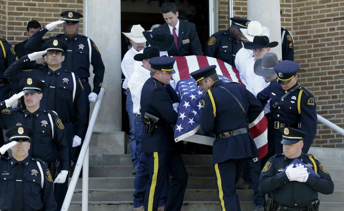 Pallbearers carry the remains of Kaufman County District Attorney Mike McLelland and his wife, Cynthia, out of the First Baptist Church of Wortham after their funeral. The couple were shot to death last Saturday in Forney, east of Dallas.