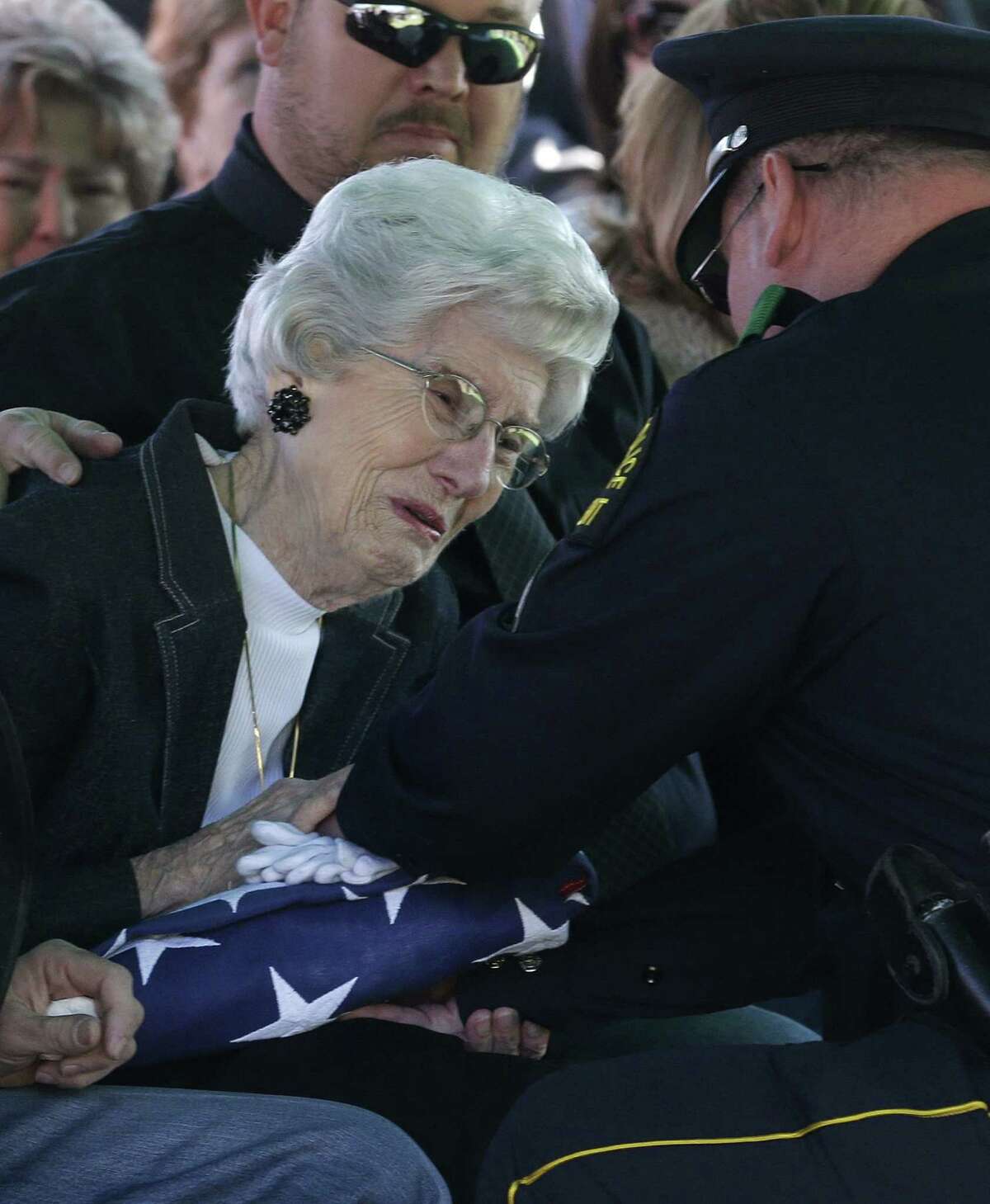 Wyvonne McLelland, mother of Mike McLelland, receives a flag from Nathan Foreman during the funeral.