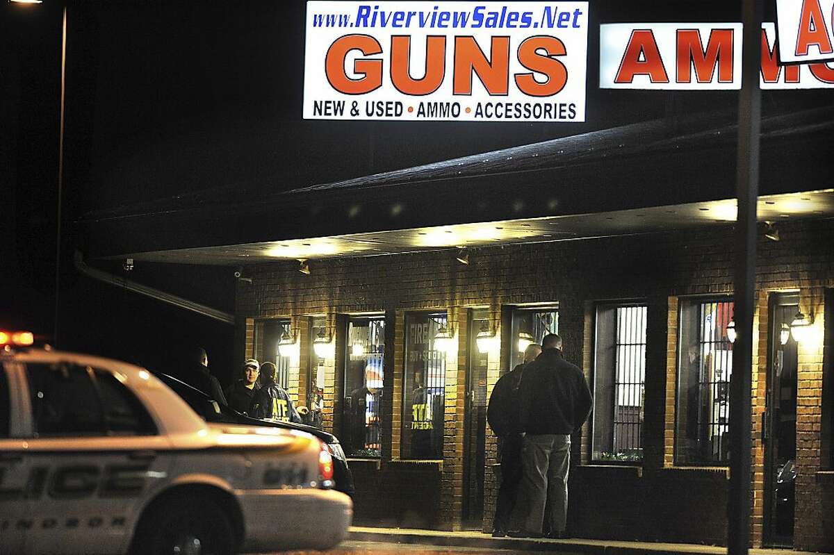 In this Dec. 20, 2012 photo, law enforcement officials stand outside Riverview Gun Sales, as authorities raid the store in East Windsor, Conn. The shop, which sold a gun to Nancy Lanza, mother of Newtown school shooter Adam Lanza, had its federal firearms license revoked by the Bureau of Alcohol, Tobacco, Firearms and Explosives. (AP Photo/Jessica Hill)
