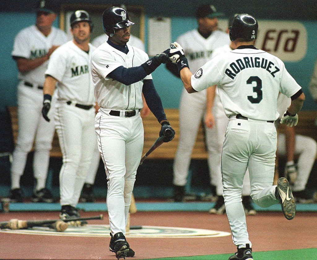 Seattle Mariners' Julio Rodriguez, center, poses for a photo with former  Mariners players Ichiro Suzuki, left, and Edgar Martinez, while holding his  AL Rookie of the Year and Silver Slugger awards, before the team's opening  day baseball game against th