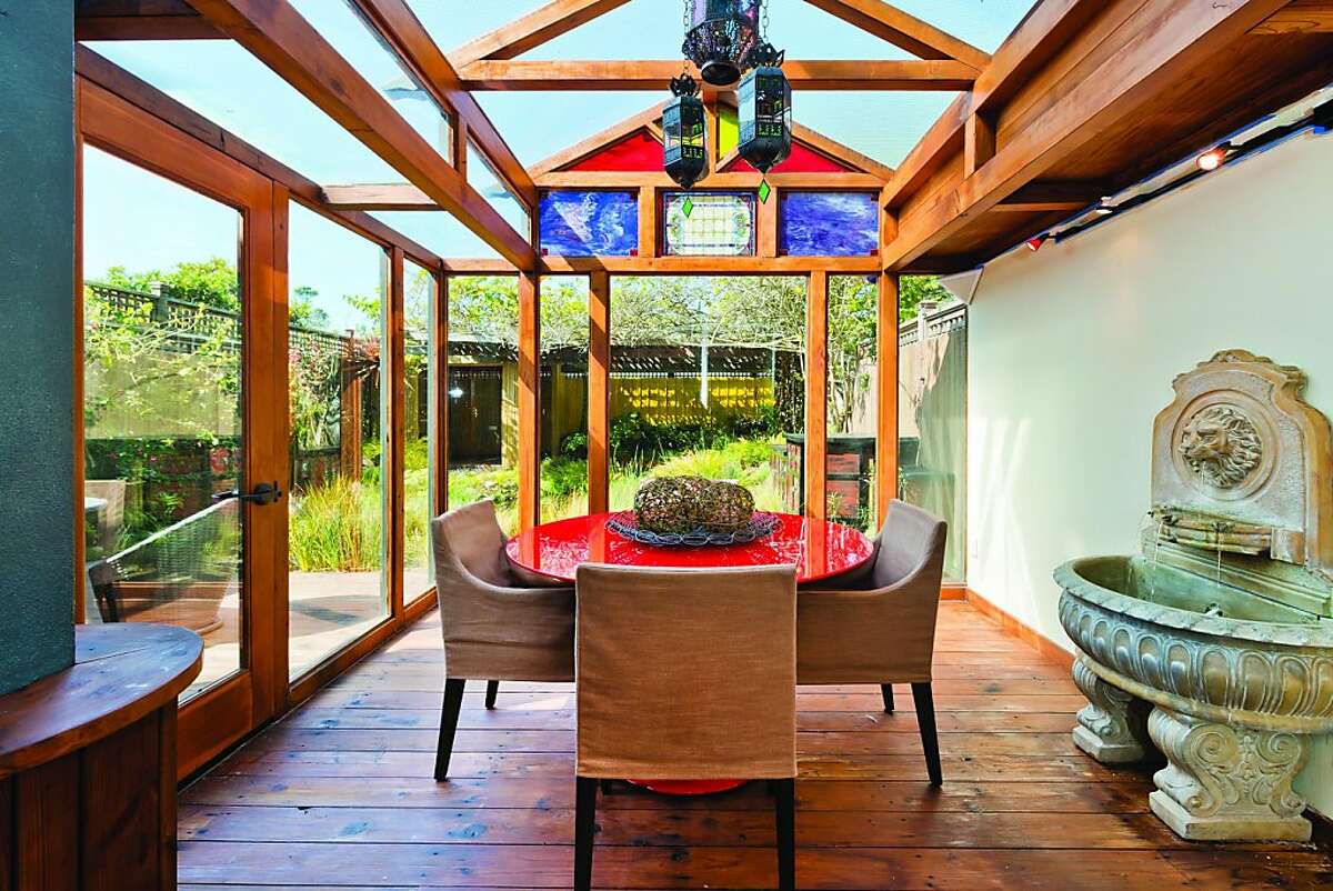 The sunroom features floor-to-ceiling windows looking at the Koi pond.