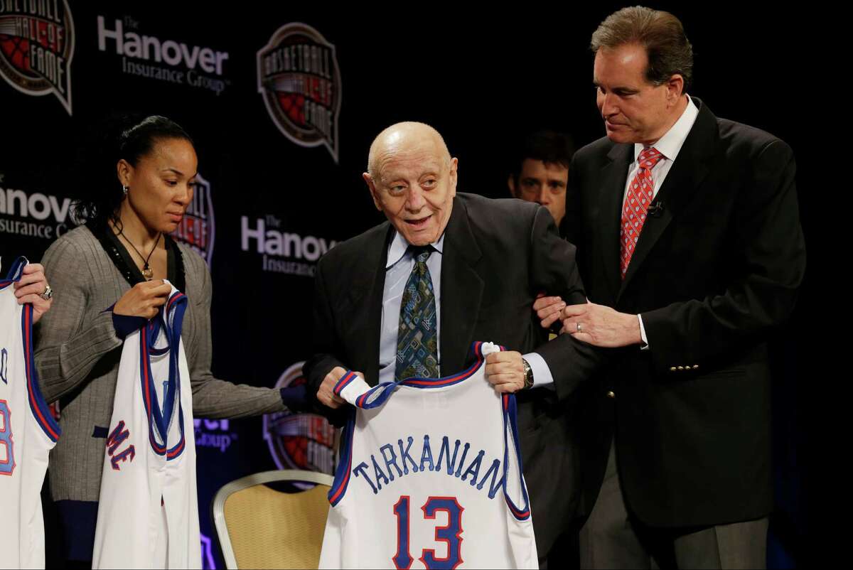 Former UNLV coach Jerry Tarkanian, center, is helped on stage by CBS announcer Jim Nantz, right, during the Naismith Memorial Basketball Hall of Fame class announcement, Monday, April 8, 2013, in Atlanta, Georgia. (AP Photo/Charlie Neibergall)