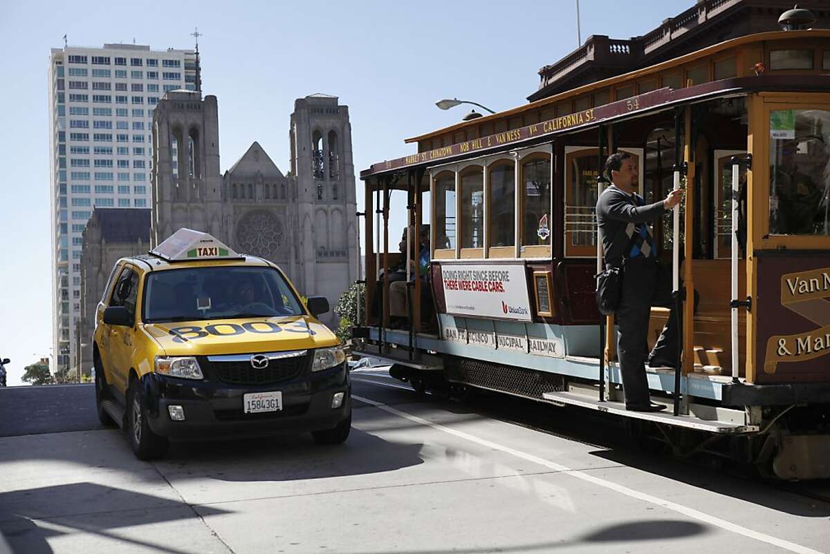 A taxi passes a cable car on California Street and Mason Street in San Francisco, Calif., on Monday, April 8, 2013. A report for the SFMTA by a taxi consultant says the city needs 600-800 more taxis.