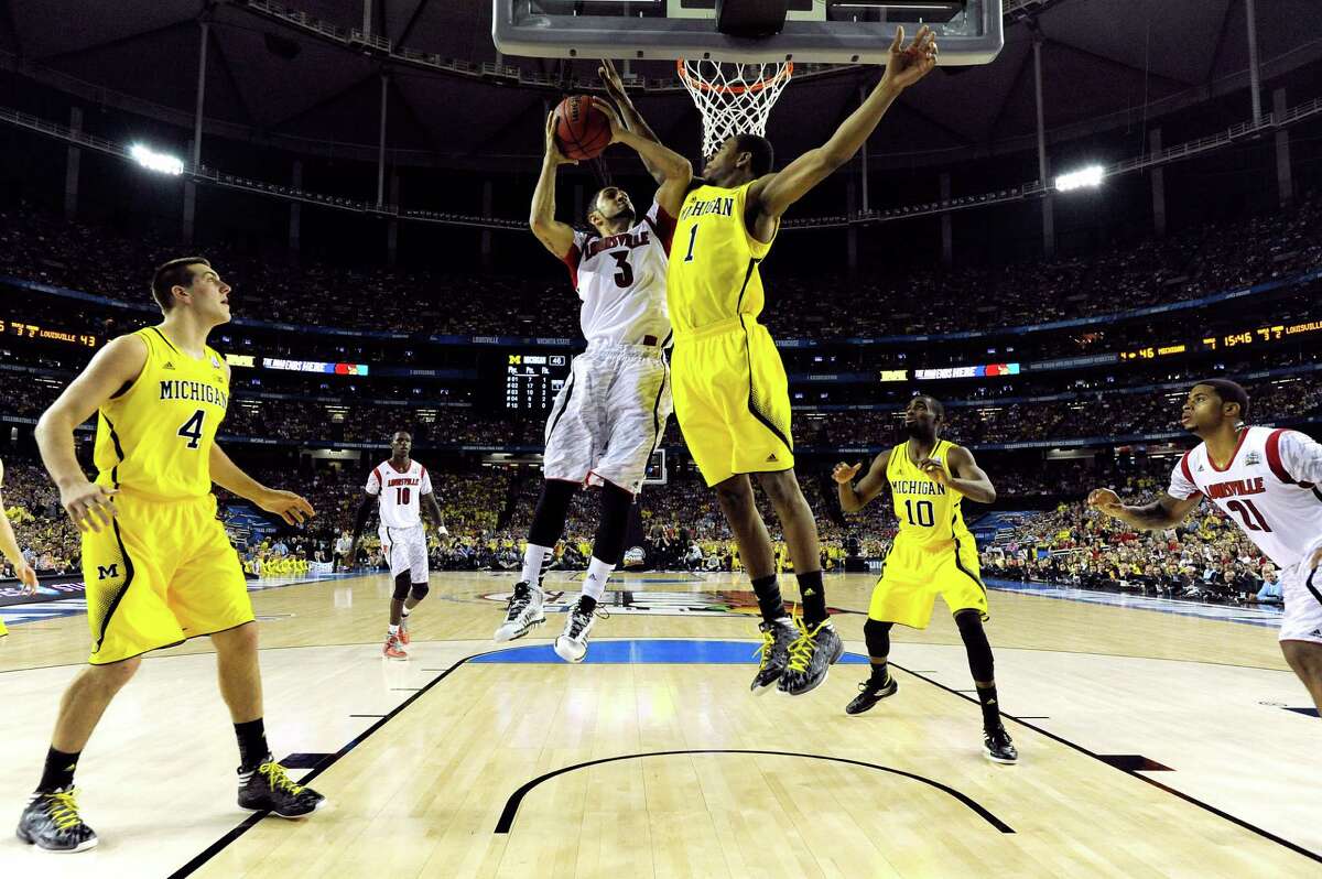 ATLANTA, GA - APRIL 08: Peyton Siva #3 of the Louisville Cardinals drives for a shot attempt against Glenn Robinson III #1 of the Michigan Wolverines during the 2013 NCAA Men's Final Four Championship at the Georgia Dome on April 8, 2013 in Atlanta, Georgia. (Photo by Chris Steppig-Pool/Getty Images)