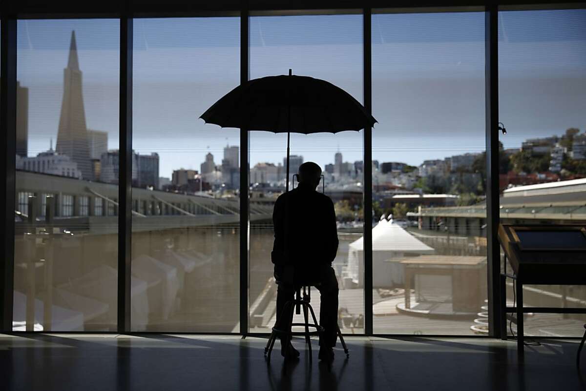 Bryan Connell, exhibit developer, sits at the Surveying in the City exhibit behind fritted glass in the Fisher Bay Observatory Gallery at the new Exploratorium on Tuesday, April 9, 2013 in San Francisco, Calif. Fritted glass helps to reduce the solar gain at the new Exploratorium.