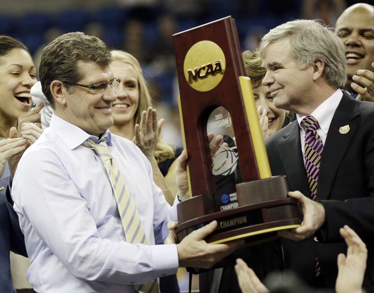 Connecticut head coach Geno Auriemma receives the championship trophy of the women\'s Final Four of the NCAA college basketball tournament, Tuesday, April 9, 2013, in New Orleans. Connecticut defeated Louisville 93-60.