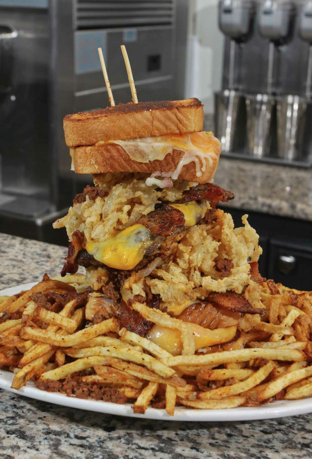 The Animal House sandwich at Ripps Grille features two 1/2-pound beef patties, chili, bacon and fried onion rings sandwiched between two grilled cheese sandwiches.