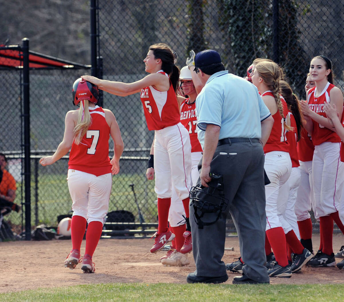 At left, Rebecca DeCarlo # 7 of Greenwich is congratulated by Jennifer Ambrogio # 5 and her teammates after hitting a homerun to lead off the game for Greenwich in the bottom of the first inning during the girls high school softball game between Greenwich High School and Stamford High School at Greenwich, Wednesday, April 10, 2013. Greenwich won the game 7-5 to remain unbeaten.