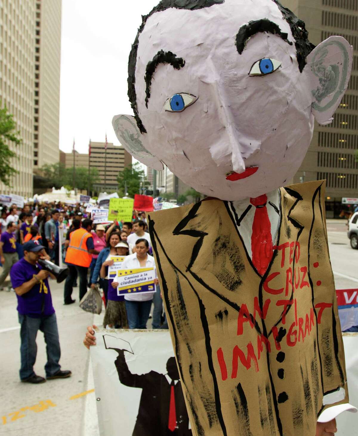 A paper mache doll of Ted Cruz is held up as hundreds of protesters marched along Smith St. to call on the Texas Senator to support immigration reform with a clear path to citizenship on Wednesday, April 10, 2013, in Houston.