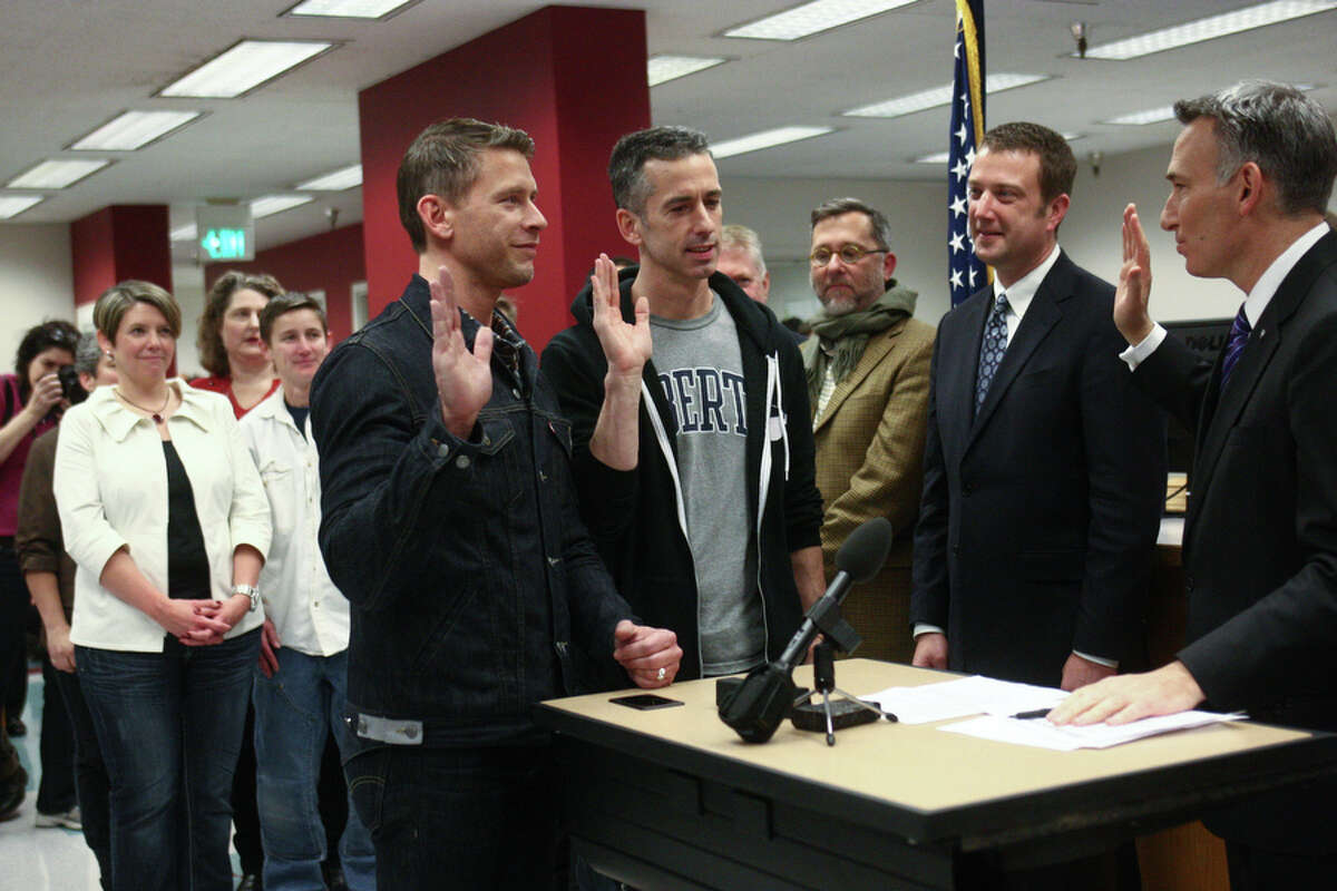 Sex advice columnist Dan Savage and his husband Terry Miller, left, apply for their marriage license at the King County Administration Building on December 6, 2012. Already wed a few years ago in Canada, they celebrated arrival of marriage equality in Washington. 