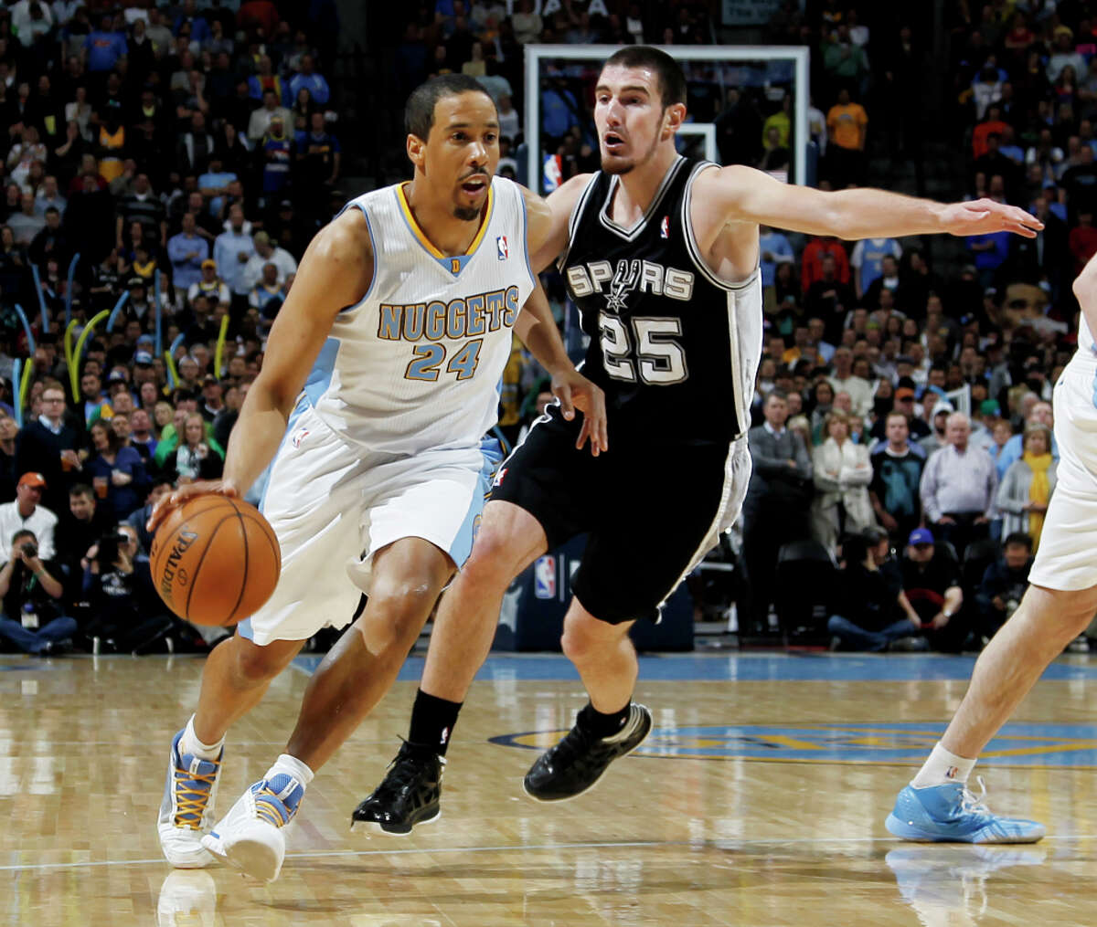 Denver Nuggets guard Andre Miller, left, drives past San Antonio Spurs guard Nando De Colo, of France, in the first quarter of an NBA basketball game in Denver, Wednesday, April 10, 2013.