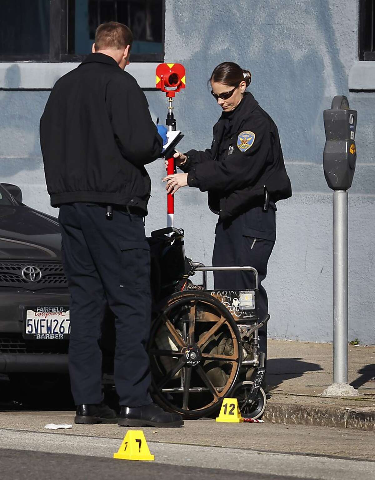 Crime scene investigators gather evidence after police officers shot a man in a wheelchair who reportedly threatened them with a knife in San Francisco, Calif., on Tuesday, Jan. 4, 2011.