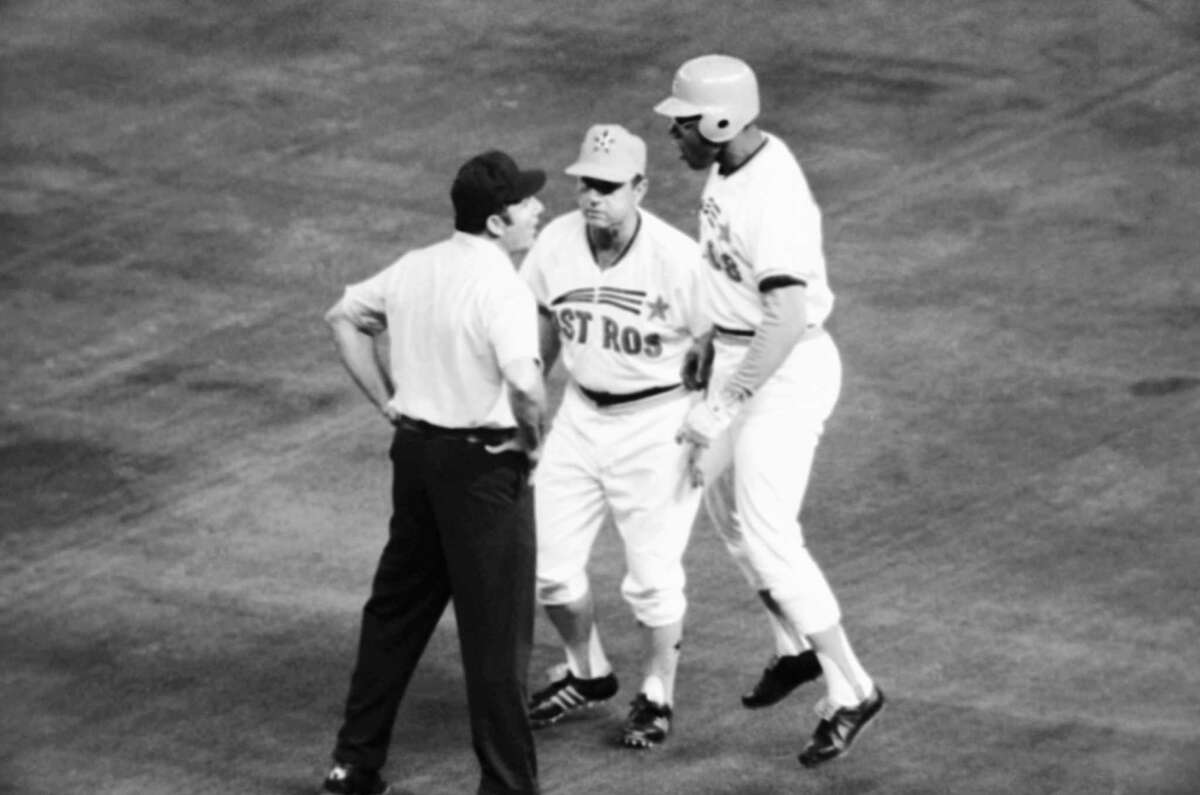 Houston Astros left fielder Bob Watson, right, hops up and down as he argues with first base umpire Dick Stello, left, over the call made on him in the third inning, April 20, 1974, Houston, Tex. Watson had grounded in the hole to short and the throw pulled the first baseman, Atlanta Ivan Murrell off the bag, but he made a tag at Watson which Stello ruled it was good for the out. First base coach Grady Hatton, center, stepped in between them and took over the argument. (AP Photo/Ed Kolenovsky)