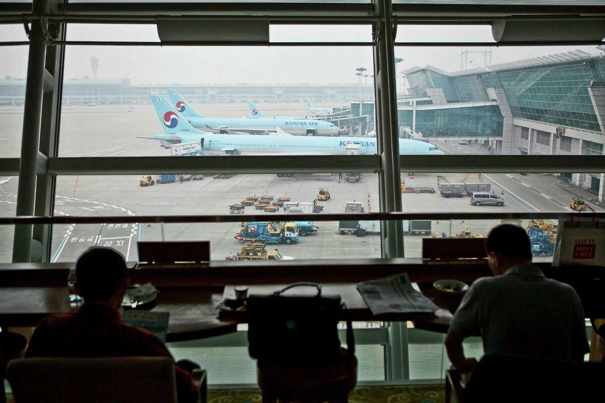 Passengers sit inside the Korean Air Lines Co. first class lounge as the company's aircraft stand on the tarmac at Incheon International Airport in Incheon, South Korea, on Friday, April 5, 2013. Korean Air, which counts Samsung Electronics Co. as its biggest source of revenue, expects passenger demand to increase 3.9 percent this year as economic growth in the U.S. and Asia, help mask a downturn in European demand. Photographer: Jean Chung/Bloomberg