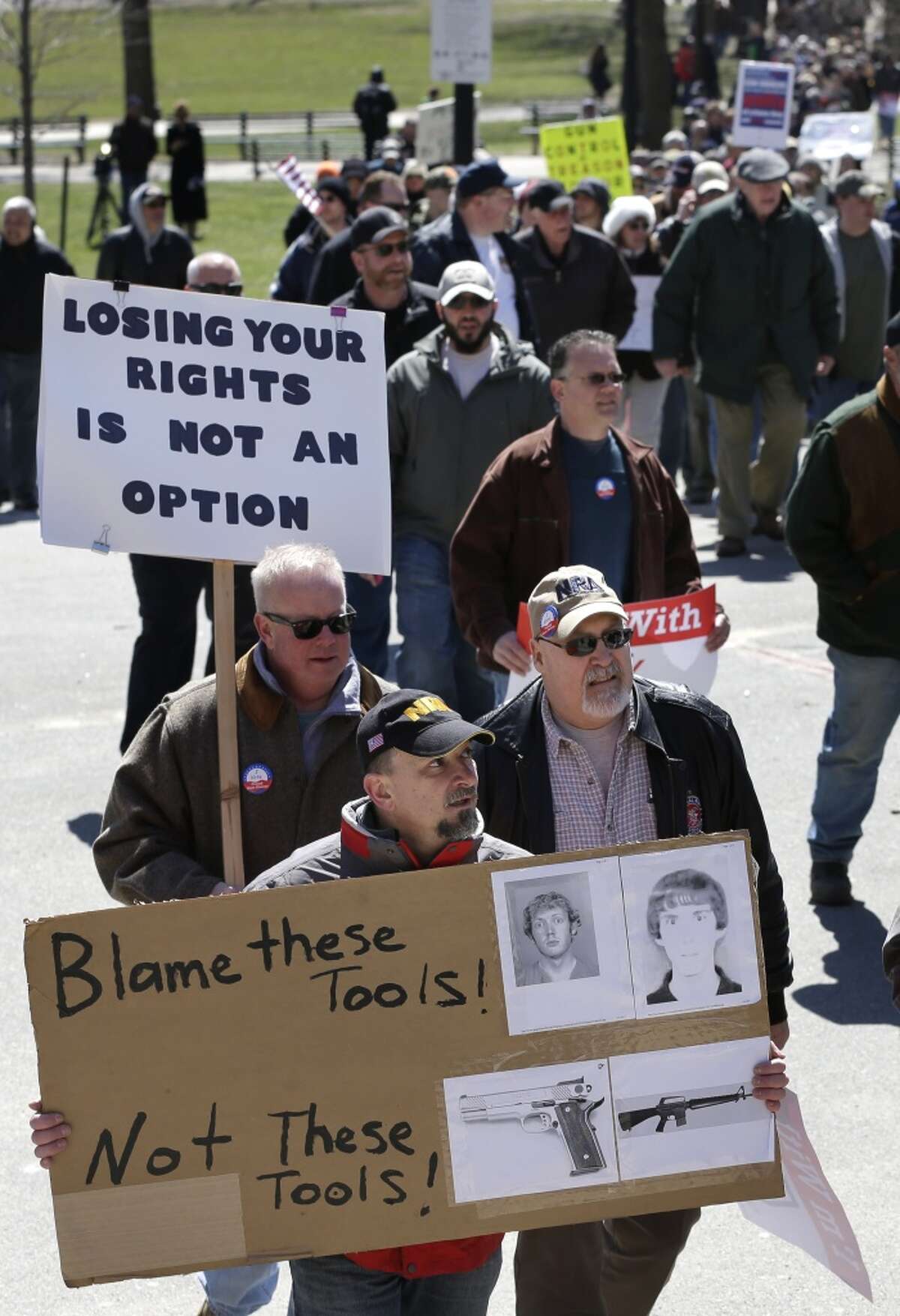 Gun owners and supporters display placards as they march toward the Statehouse, in Boston, Wednesday, April 3, 2013. The demonstration and rally, organized by the Gun Owners Action League, was held to call attention to Second Amendment rights as gun control advocates push for tougher laws in Massachusetts in the wake of the deadly shooting at an elementary school in Newtown, Conn.