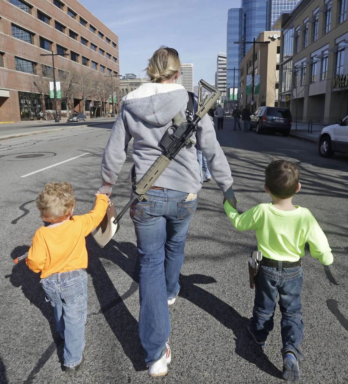 Gun rights activist Siri Davidson, center, has her AR15 slung on her back, as she walks with her children Keaton, 2, and Porter, 5, during a march for the 2nd Amendment rights Saturday, March 2, 2013, in Salt Lake City.