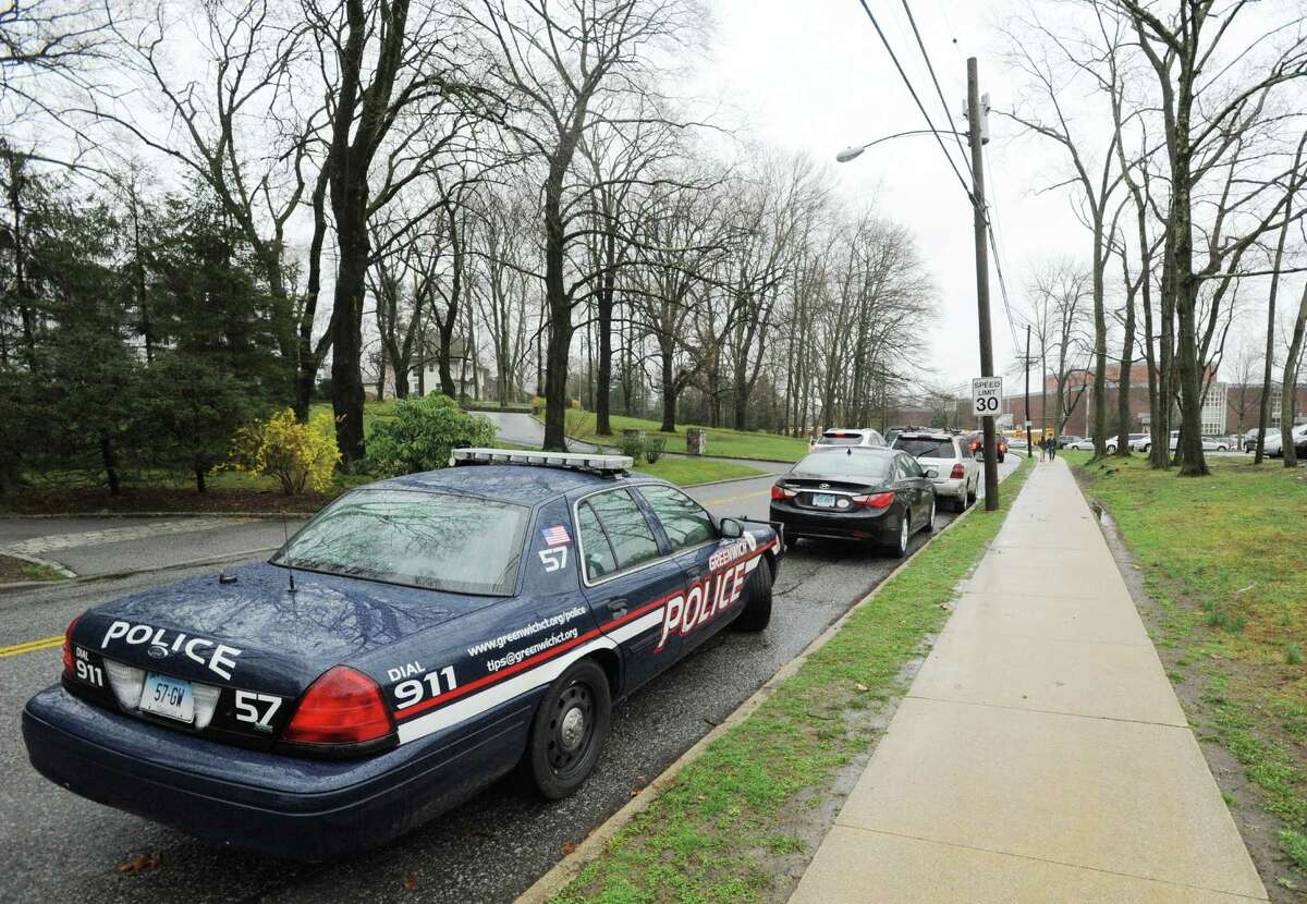 A Greenwich Police car parked on Hillside Road during dismissal at Greenwich High School Friday afternoon, April 12, 2013, the day after a student's false threat of a gun sent the campus into a lockdown.