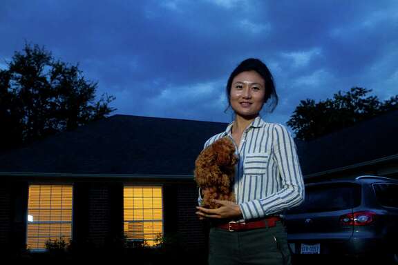 Faye Liu, holds her dog, Toffee, as she stands in front of the home she rents, Wednesday, April 3, 2013, in Houston. Faye Liu and her husband is Jiang Wu moved to Houston last September for Faye's job as a geologist at a Houston energy company and they're looking to buy a house in the Energy Corridor. Jiang, 35, works in the Texas Medical Center and they both moved here from Bloomington, Indiana after getting their PhDs from Indiana University. There are few houses that come up for sale, and when they do, they go fast. They're competing with cash buyers who have an advantage because it's easier for the seller to close. They've upped their budget from $200,000 to more than $330,000. (Cody Duty / Houston Chronicle)