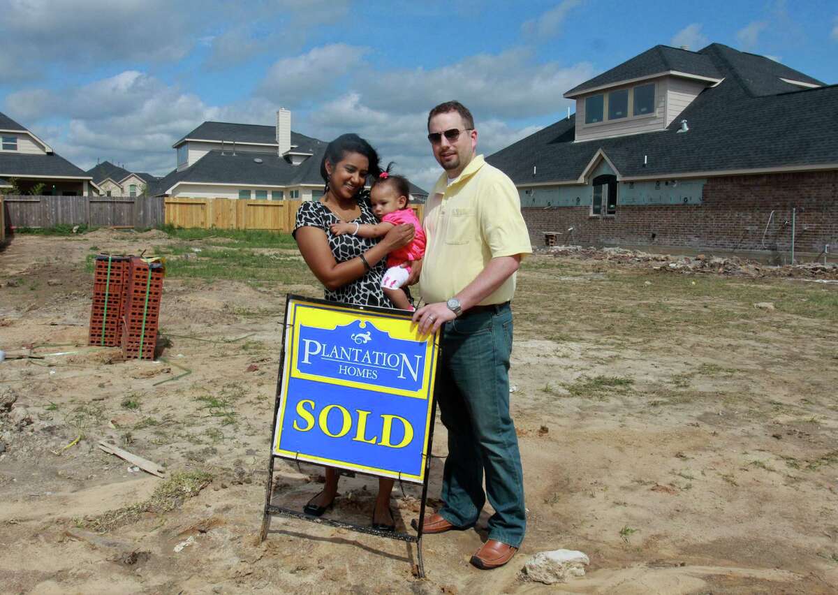 (For the Chronicle/Gary Fountain, April 5, 2013) Saritha and David Bowles, with their daughter Sita, eleven-months-old, at the location of their new home. Construction doesn't start for a few weeks. They spent nearly three months looking at about thirty homes before deciding on a new build in Rosenberg.