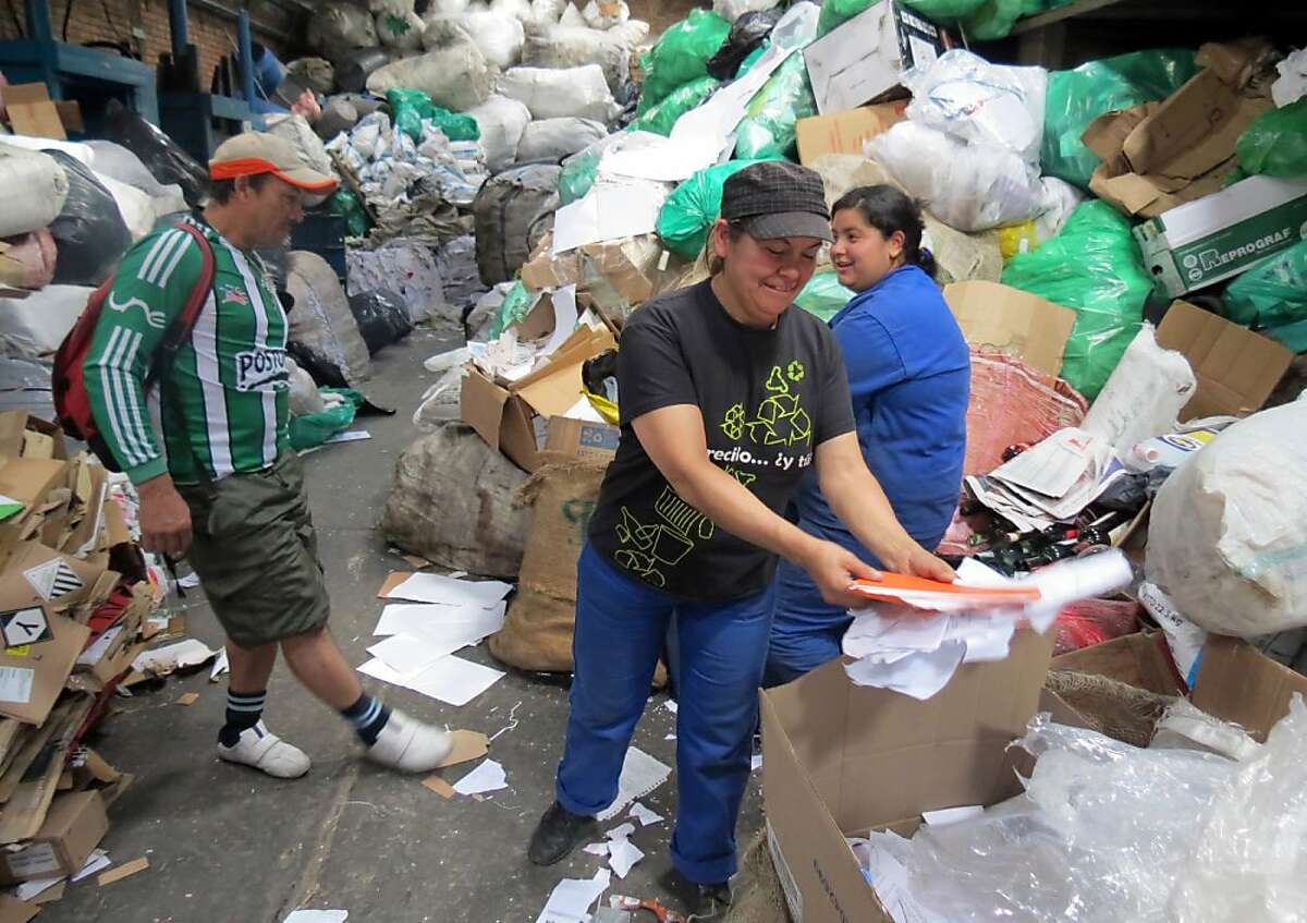 Blanca Cecilia Lopez, center, sorts paper for recycling in the Pensilvania recycling facility in Bogota, Colombia