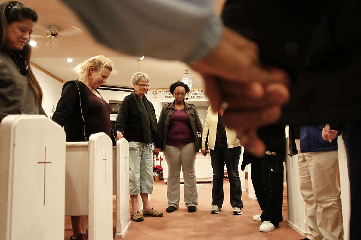 Member close the gathering with a prayer as the anti-violence group Operation Ceasefire returned to the New hope baptist Church from their weekly walk through the North Richmond, Ca. neighborhoods on Friday April 12, 2013. Police and community outreach workers say that anti violence actions have contributed to a drop in violent crimes.