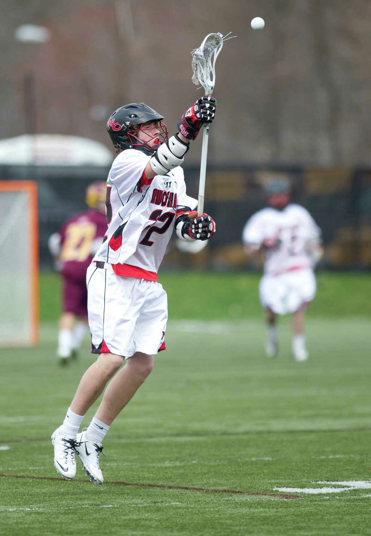 New Canaan's Graham Wagner catches a pass during Saturday's boys lacrosse game against St. Joseph at New Canaan High School on April 13, 2013.