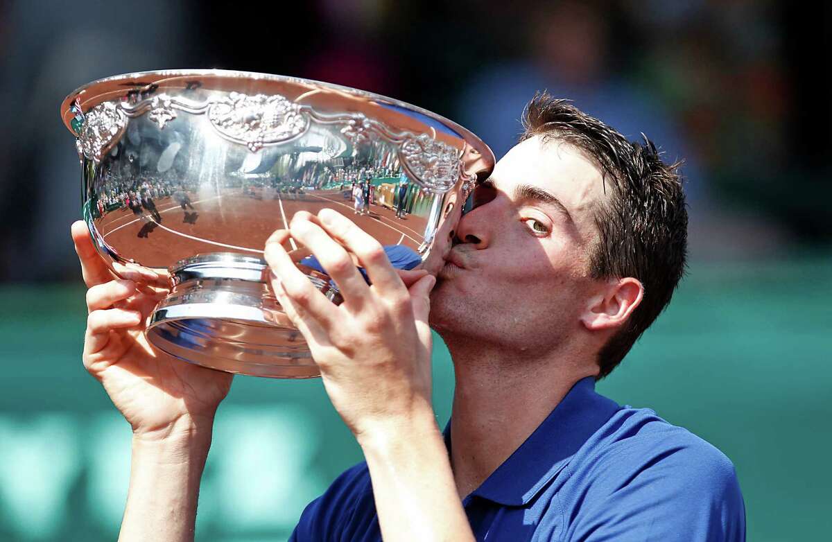 4/14/13: John Isner (USA) kisses the trophy after defeating Nicolas Almagro (ESP) in the finals of the River Oaks US Men's Clay Court Championship at River Oaks Country Club in Houston, Texas. Isner won 6-3, 7-5.