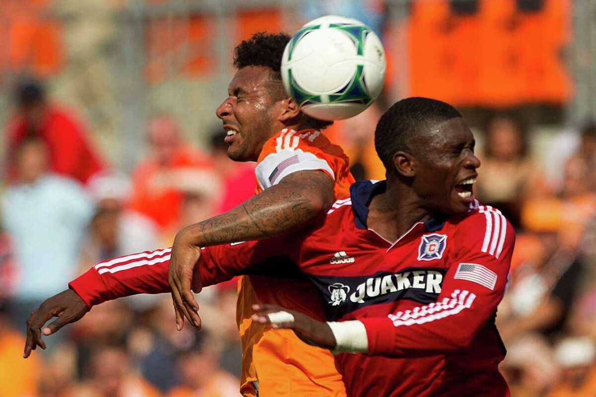 Dynamo midfielder Giles Barnes, left, and Fire defender Jalil Anibaba, right, feel the pain of trying to gain possession during the first half Sunday.