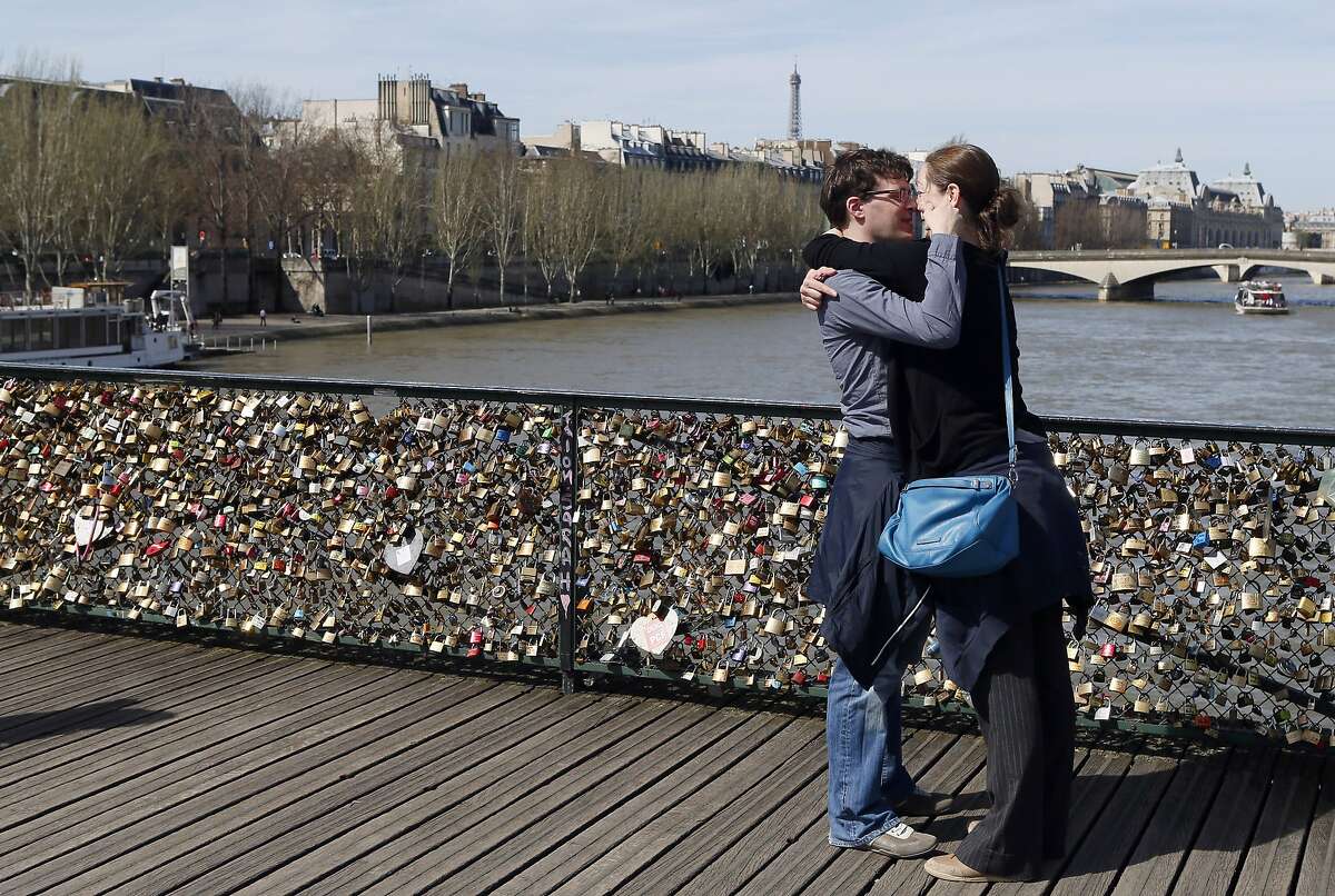 A couple kisses after hanging a love padlock on the steel bar of the Pont des Arts on April 14, 2013 in Paris. AFP PHOTO / PATRICK KOVARIKPATRICK KOVARIK/AFP/Getty Images
