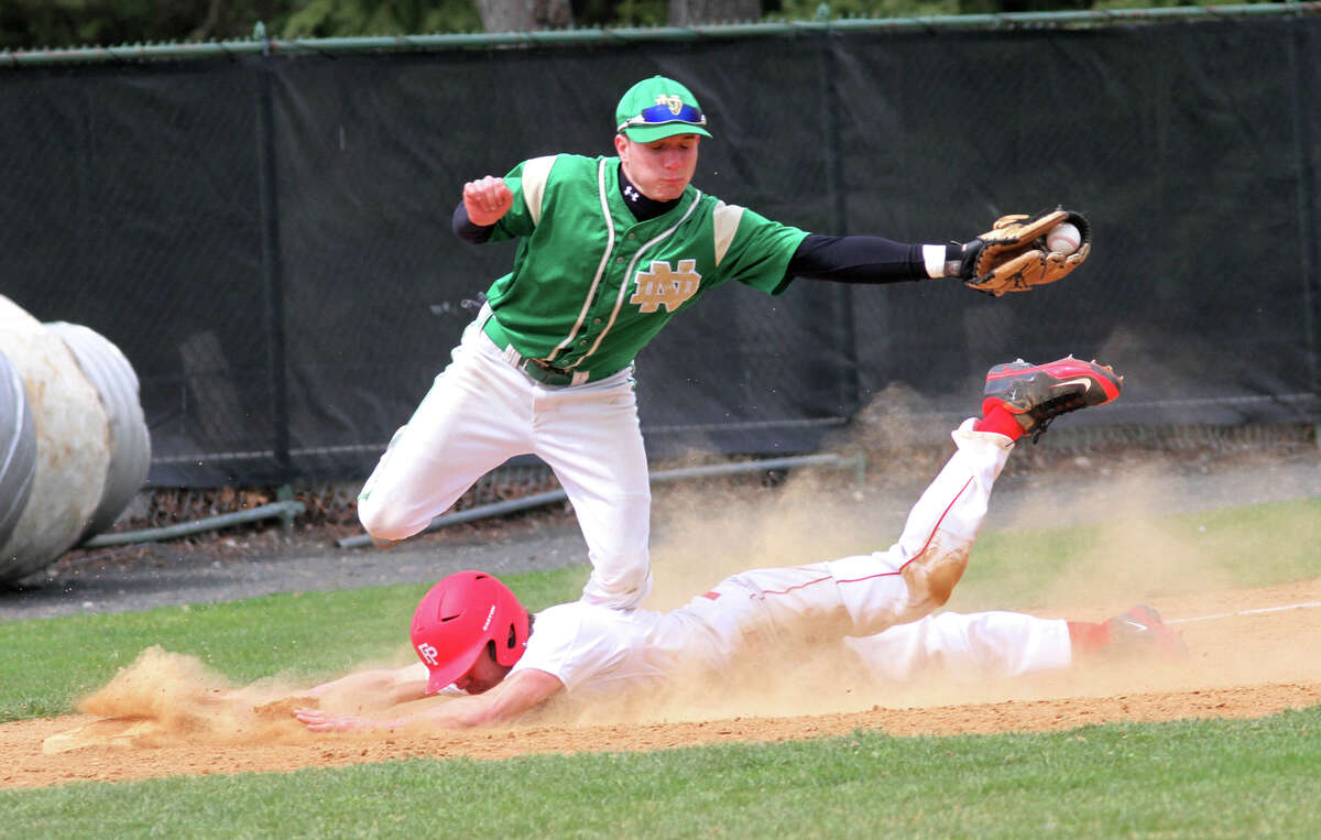 Fairfield Prep's David Gerics, 6, slides safely into third and under Notre Dame-West Haven's Zachary Korwek, 9, during a game on Monday, April 15, 2013. P