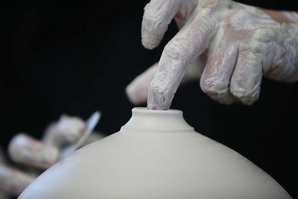 Hsin-Chuen Lin, pottery instructor, crafts a vase in the plum bottle style on a potter's wheel in his studio on Monday, February 2, 2013 in Fremont, Calif. Lin makes instructional videos for potters which he posts on YouTube.