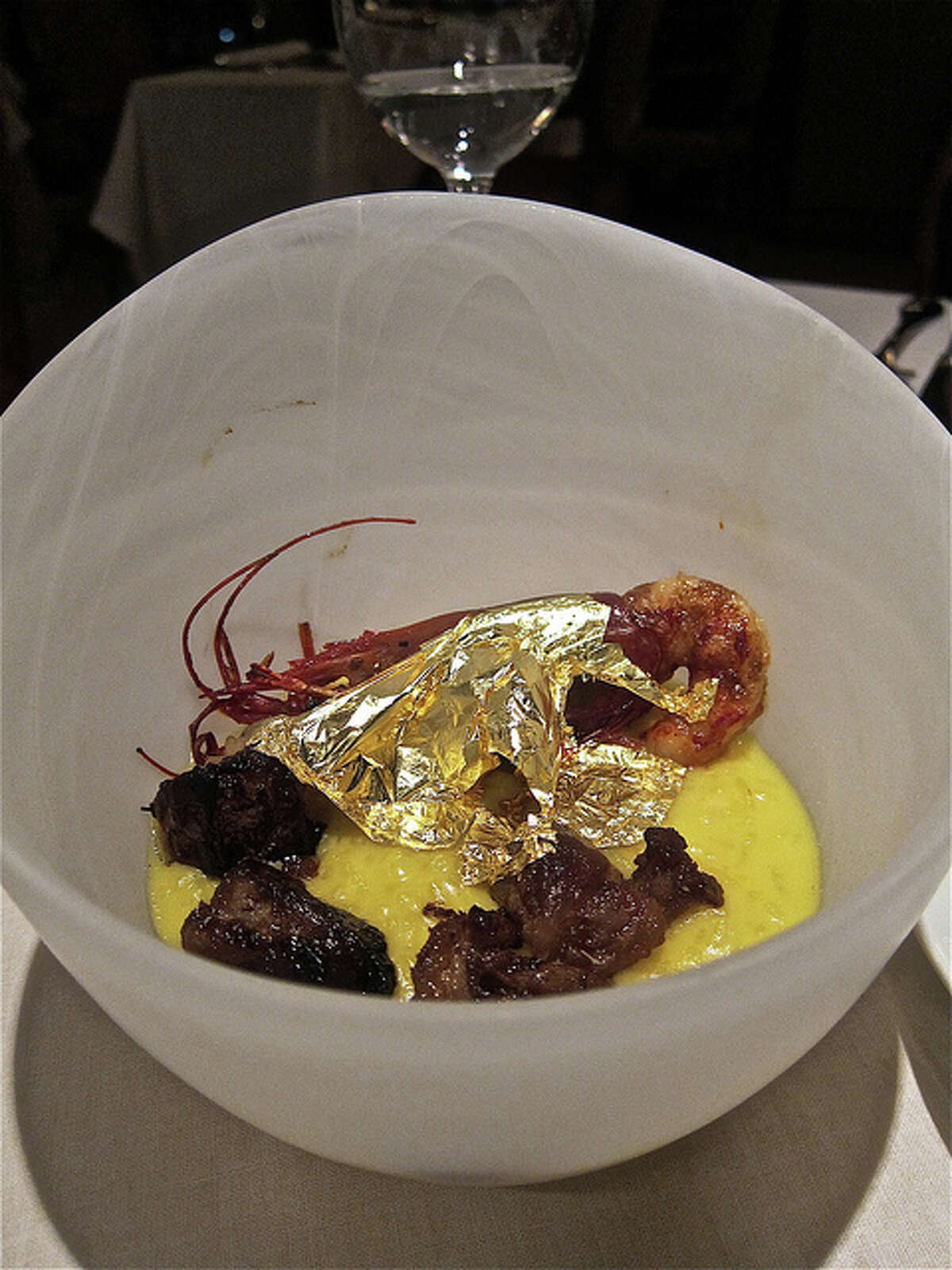 Risotto with bone marrow and whole prawn blanketed with edible gold leaf, at Ristorante Cavour