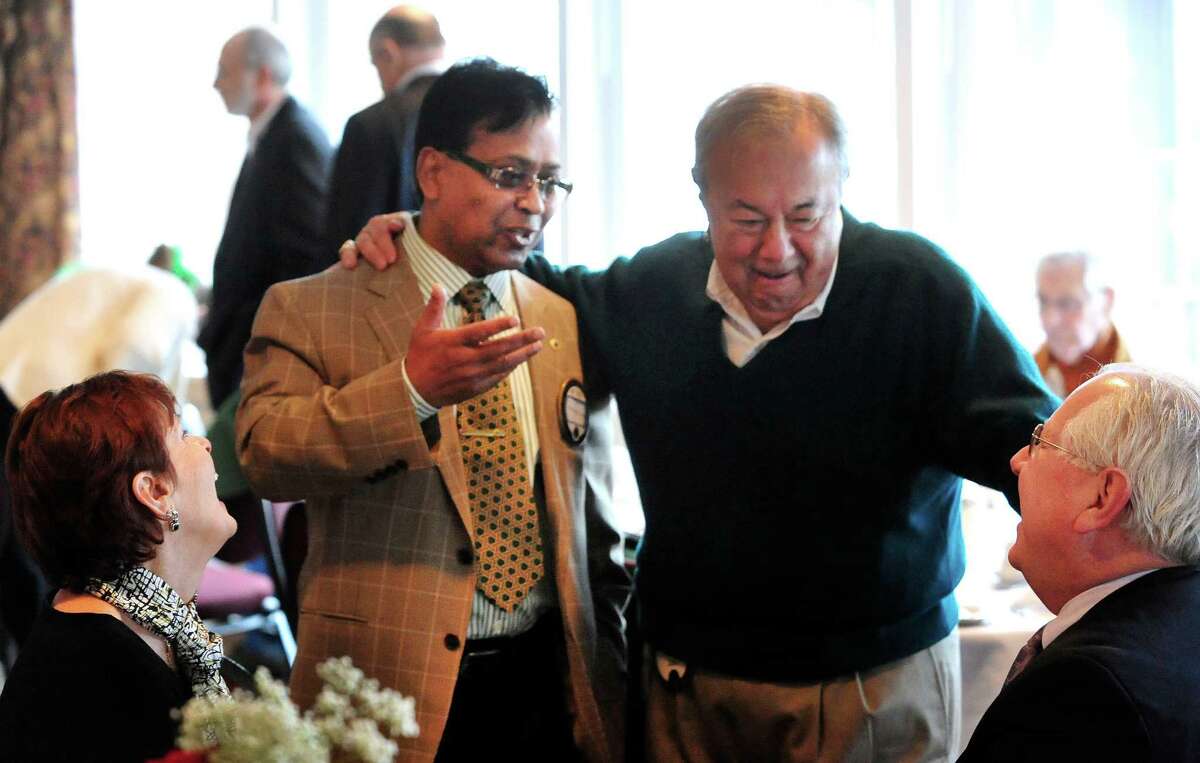 Mohammad Alam, standing left, and Frank Molinaro, club secretary, talk with other members, including Wayne Shepperd, right, during the weekly luncheon meeting of the Danbury Lions Club, at Anthony's Lake Club in Danbury, Conn. Thursday, March 14, 2013.