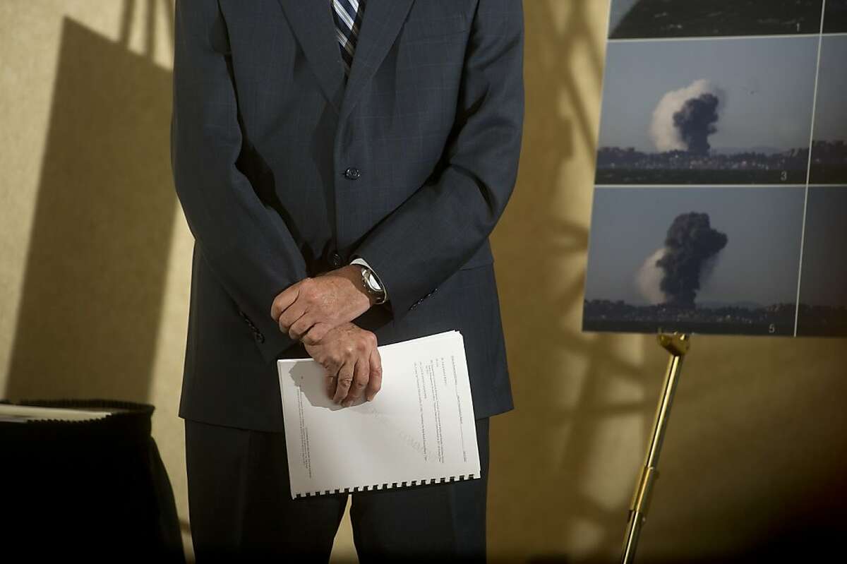 Don Holmstrom, an investigator for the U.S. Chemical Safety Board, holds a copy of his agency's interim report on a 2012 Chevron refinery fire during a press conference Monday, April 15, 2013, in Emeryville, Calif.
