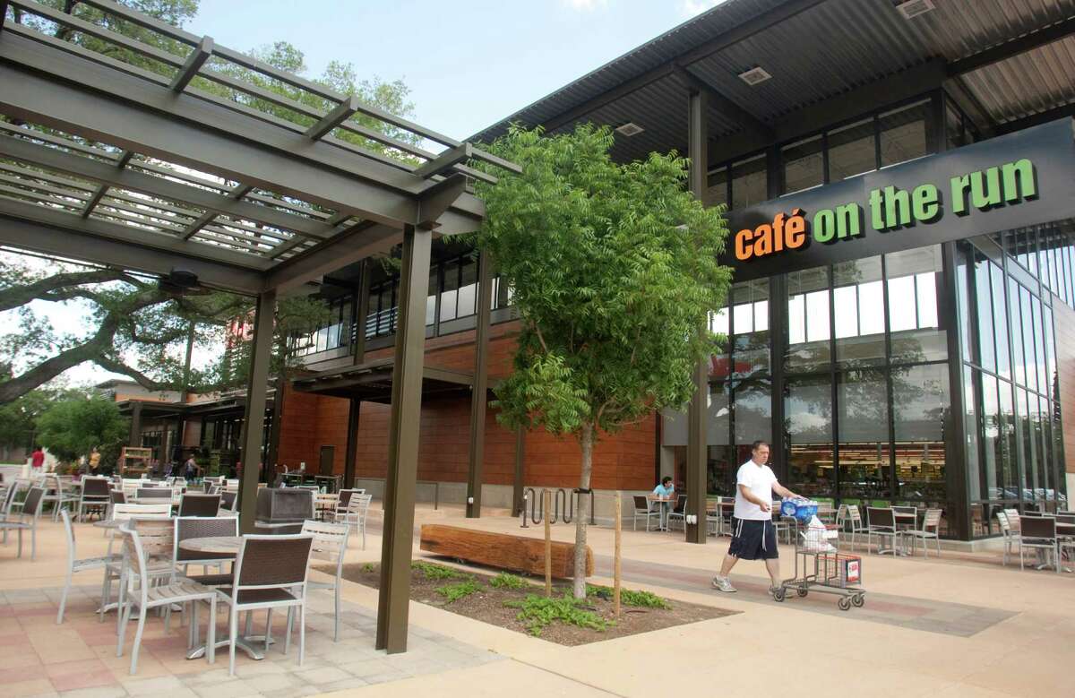 Shoppers walk past the Cafe on the Run, which offers indoor and outdoor dinning, at the new H-E-B in Montrose on Tuesday, May 29, 2012 in Houston, Texas.